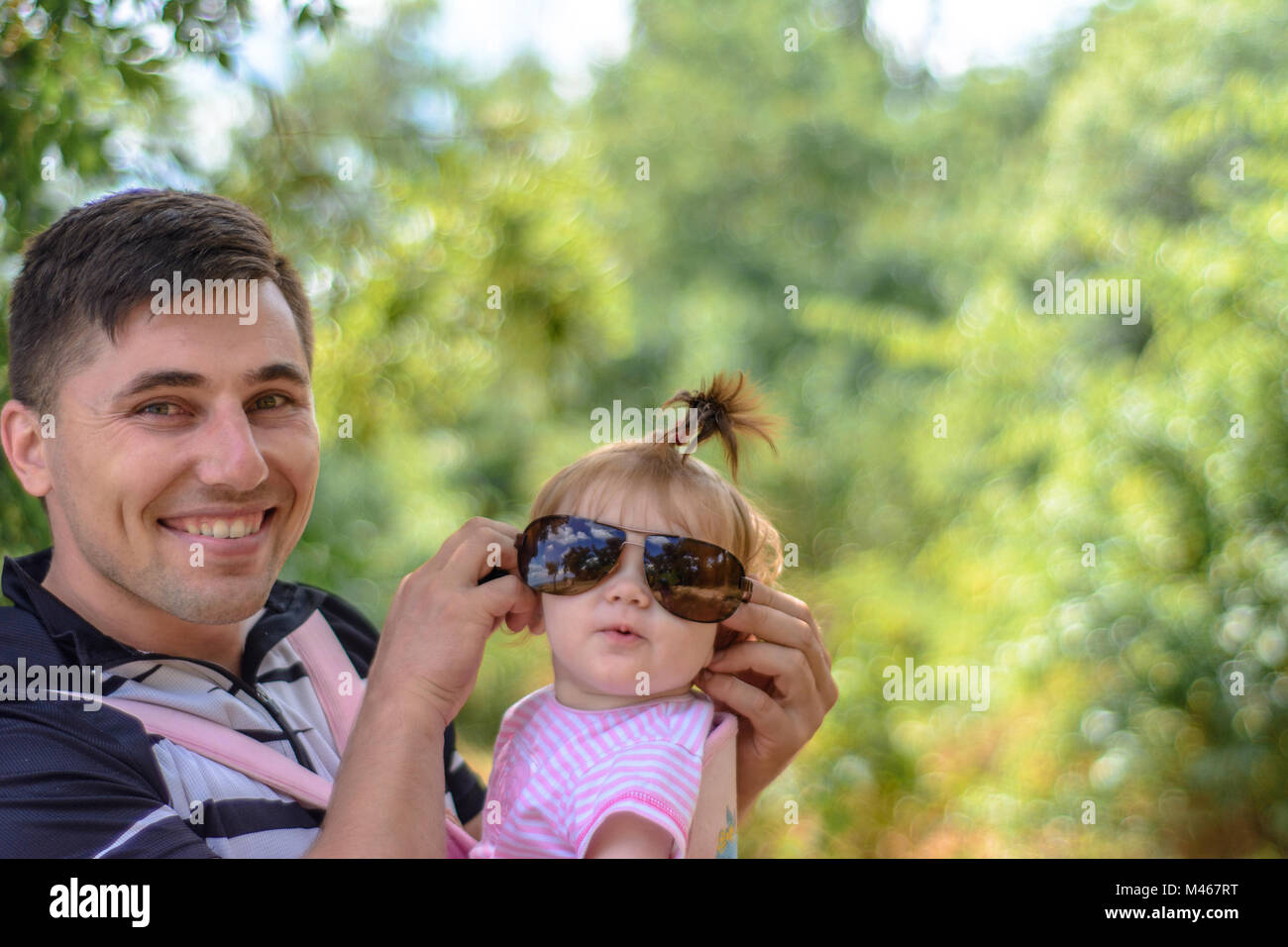 Amazing little girl is playing with sunglasses with her father Stock Photo