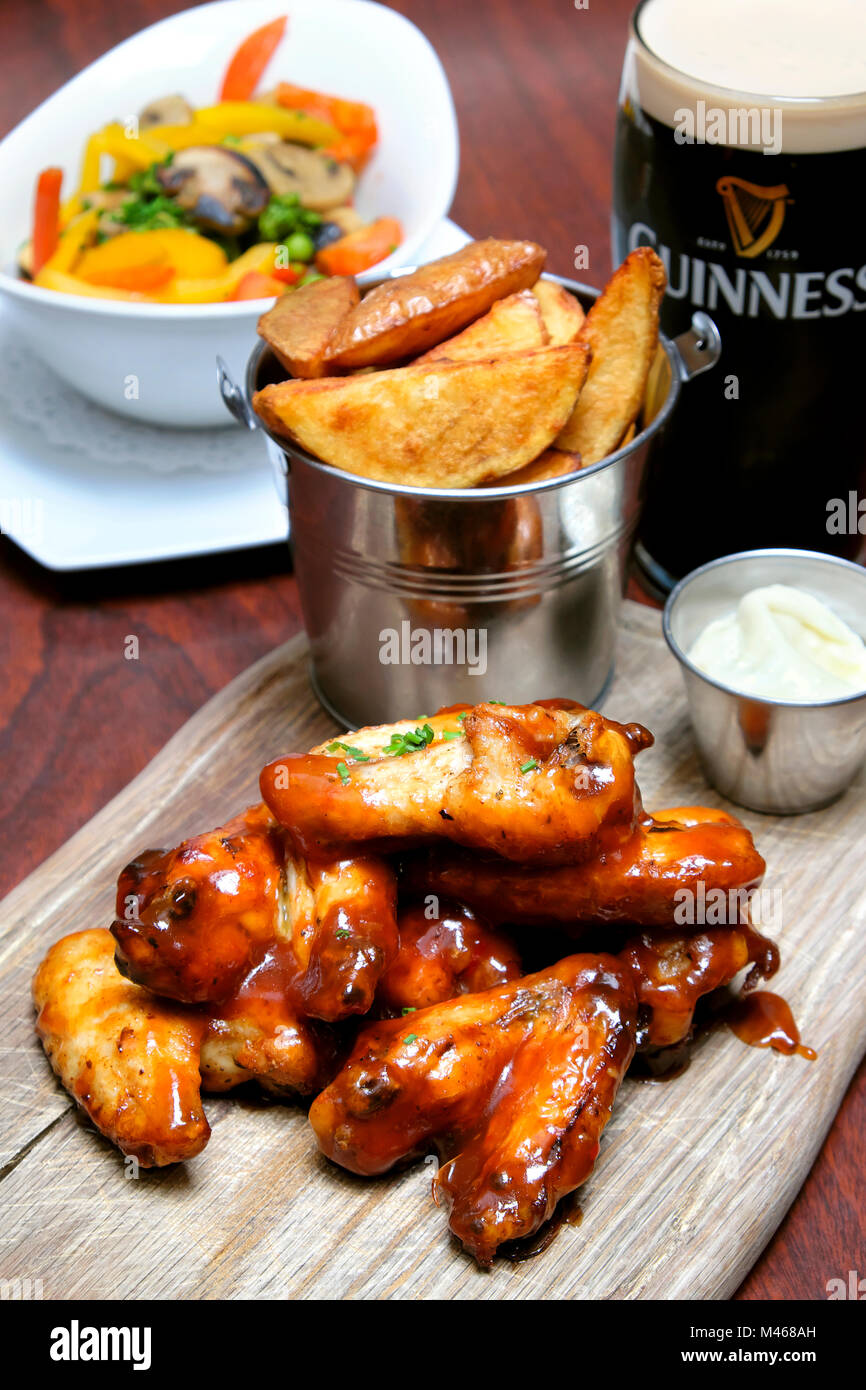 Chicken wings tossed in bbq and sweet chilli sauce served with blue cheese dip, chips and a pint of Guinness, Doheny & Nesbitt Pub, Dublin, Ireland Stock Photo