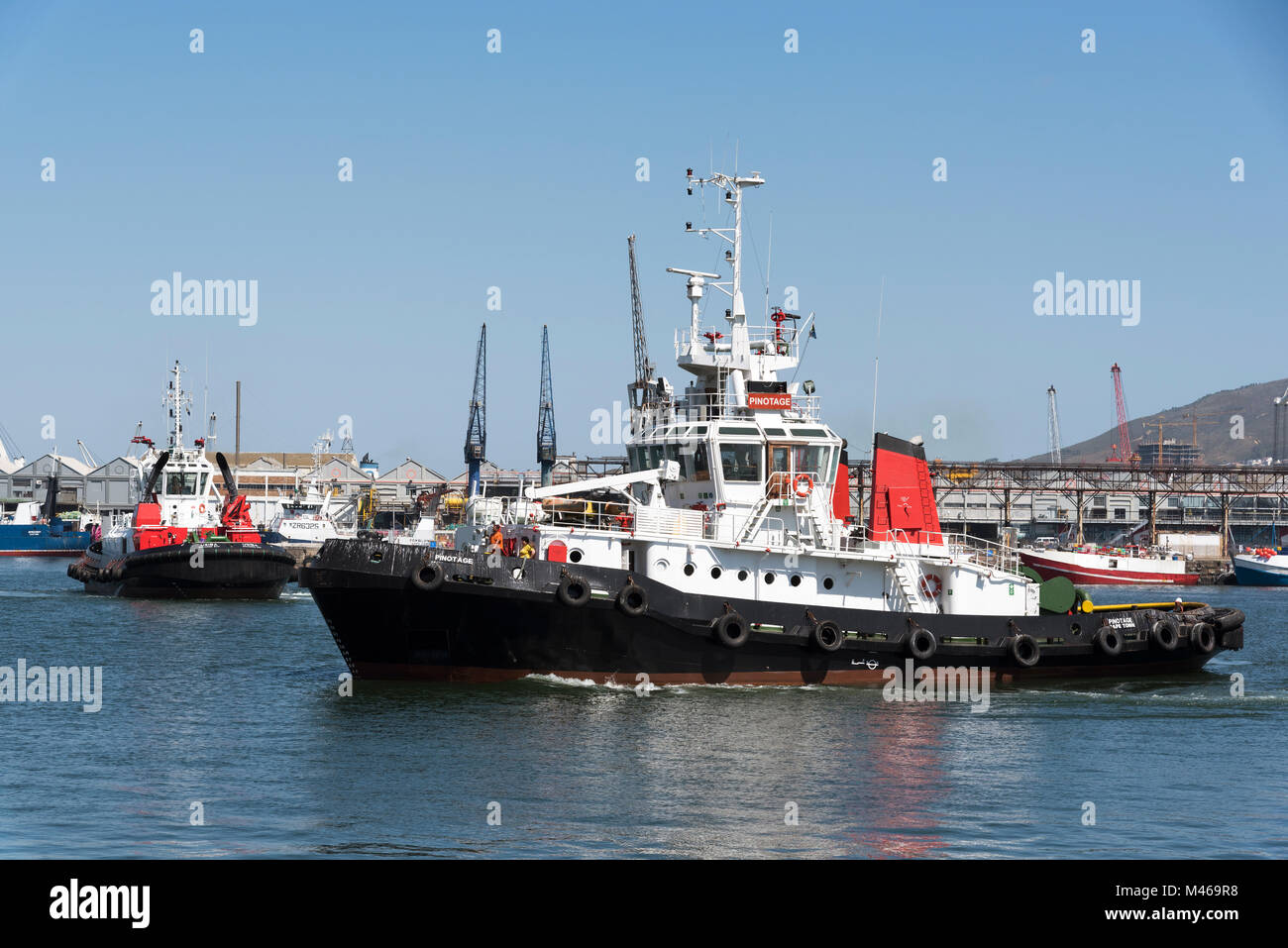 Two ocean going tugs, Pinotage and Usiba underway on Cape Town harbour South Africa. December 2017 Stock Photo