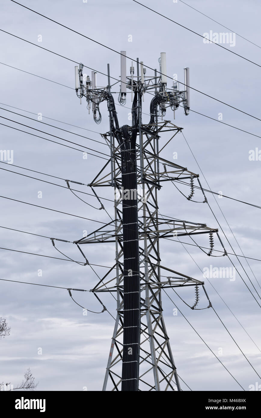 communication antennas on electrical power transmission line towers Stock Photo