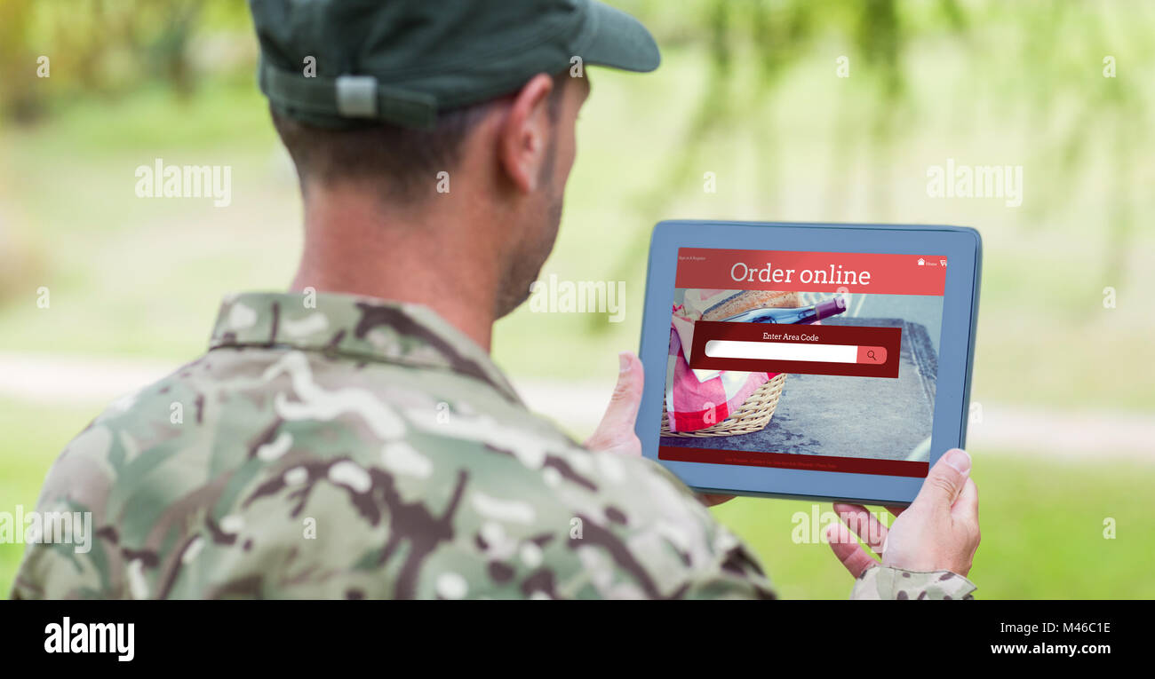 Composite image of army man using tablet Stock Photo