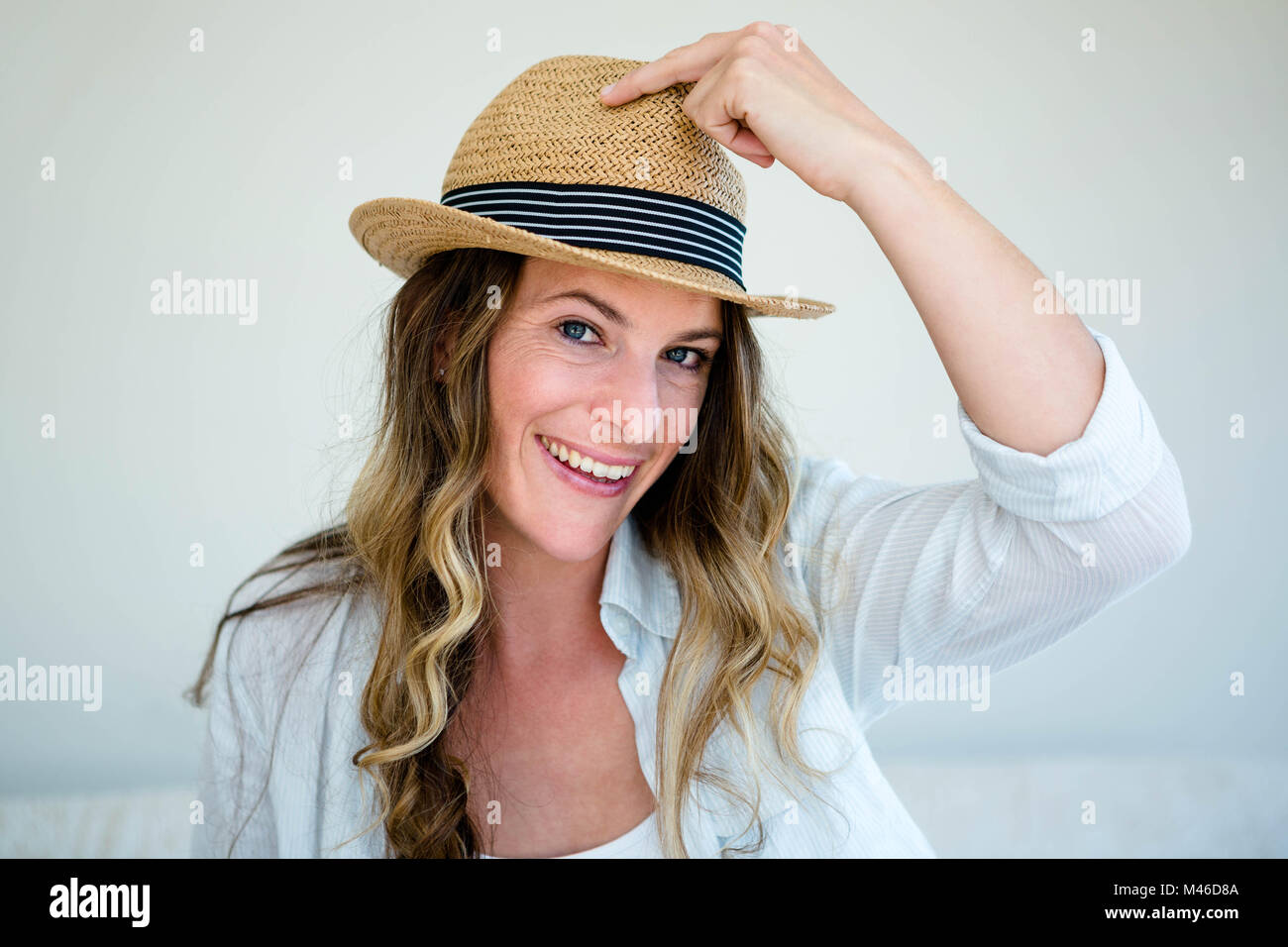 woman wearing a straw fedora smiling into the camera Stock Photo