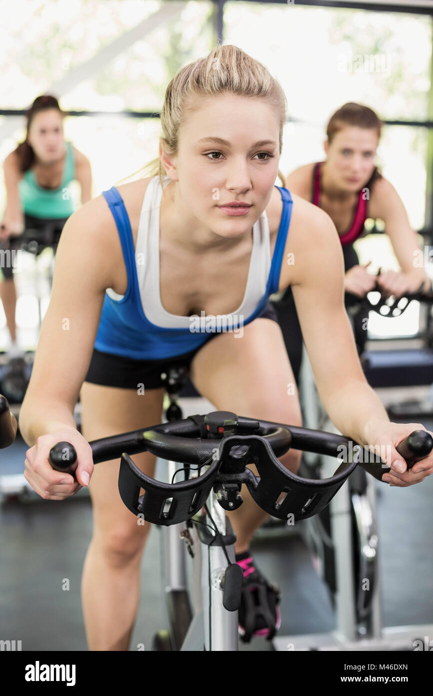 Fit group of people using exercise bike together Stock Photo