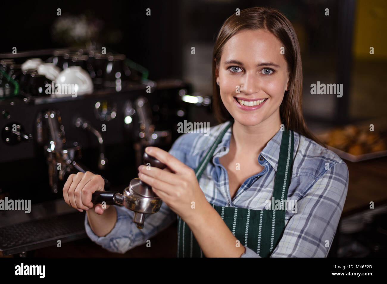 Pretty barista pressing coffee for coffee machine Stock Photo - Alamy