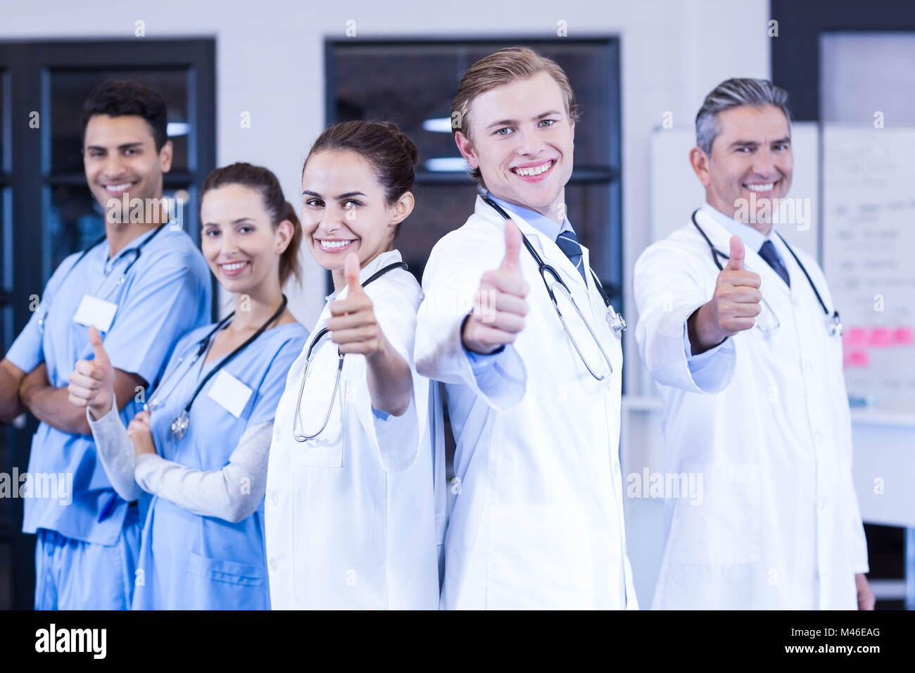 Medical team putting their thumbs up and smiling Stock Photo - Alamy