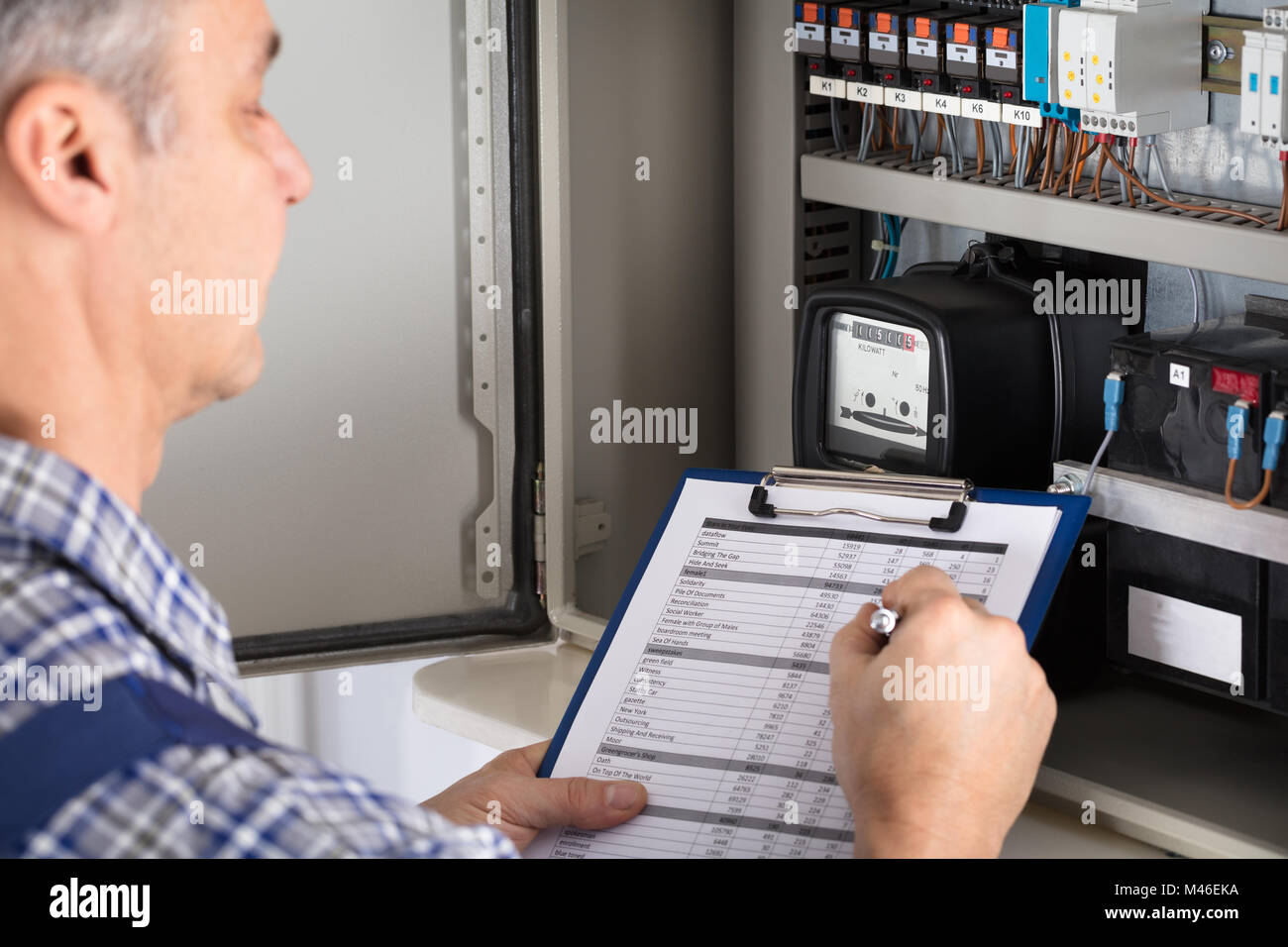 Close-up Of A Male Technician Writing Reading Of Meter On Clipboard Stock Photo