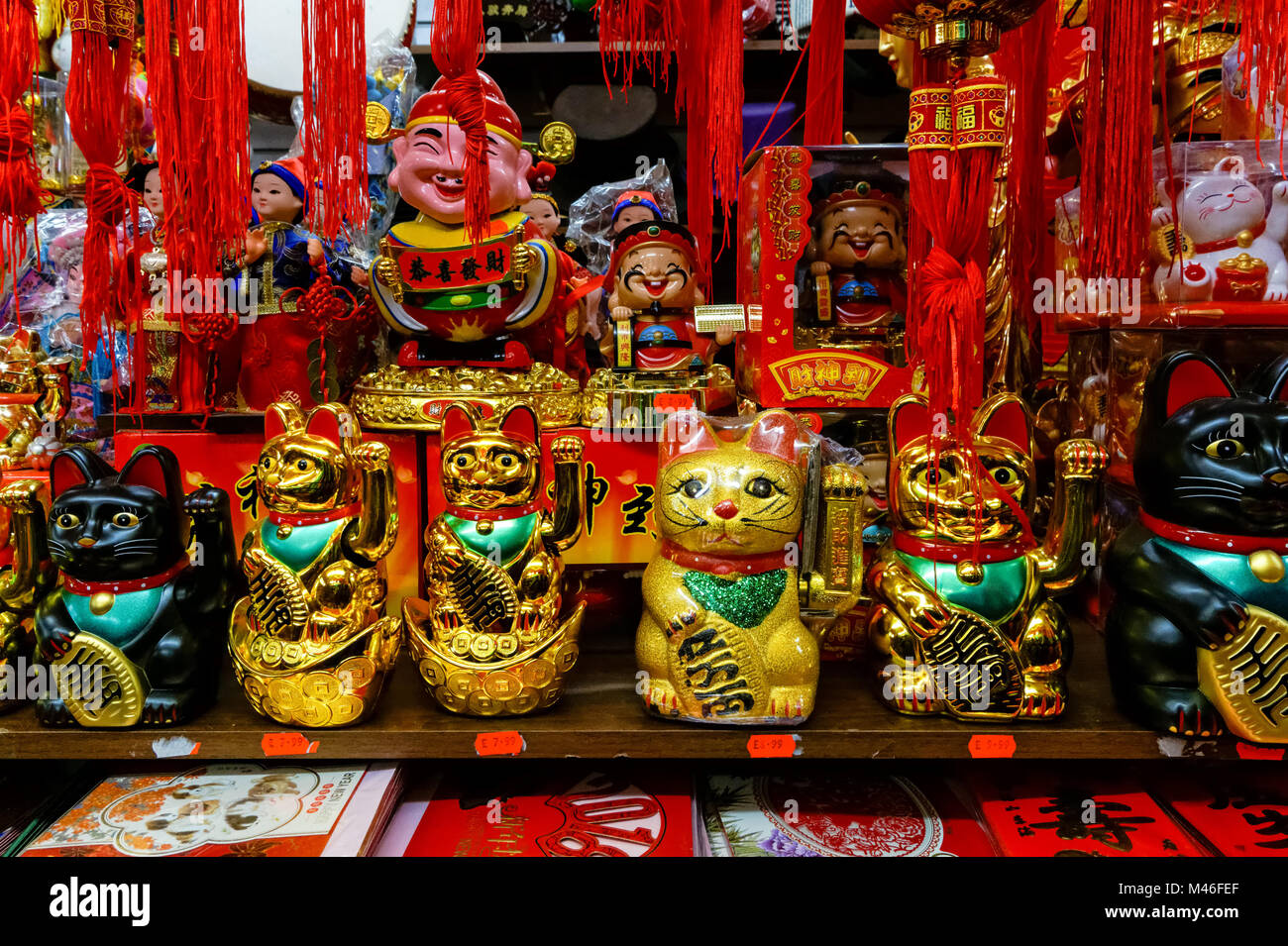 Lucky fortune cats, Maneki Neko, for sale in souvenir shop in Chinatown, London England United Kingdom UK Stock Photo