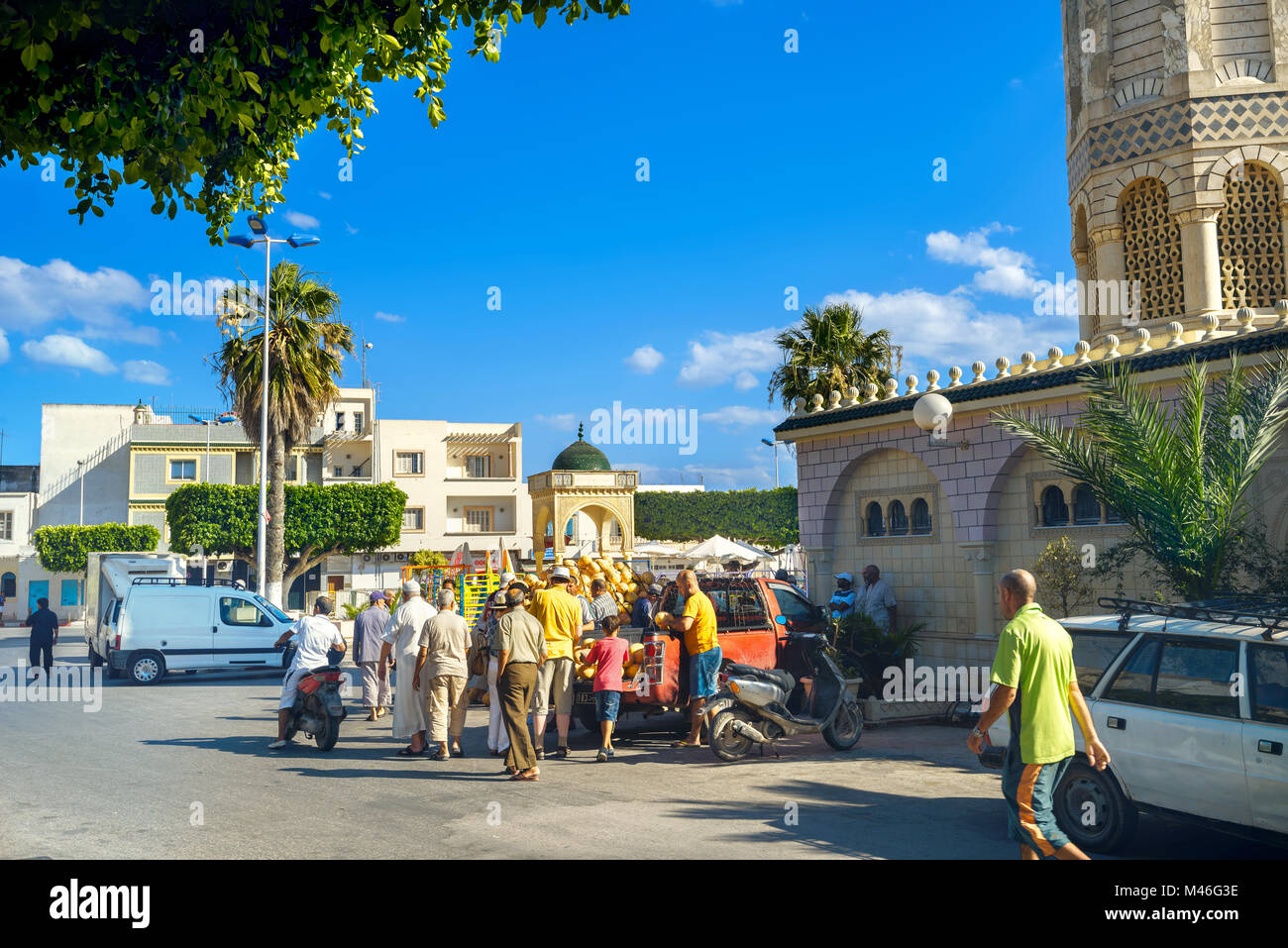 Street scene with trading of melons in casual market. Cityscape near mosque in old town. Nabeul, Tunisia Stock Photo