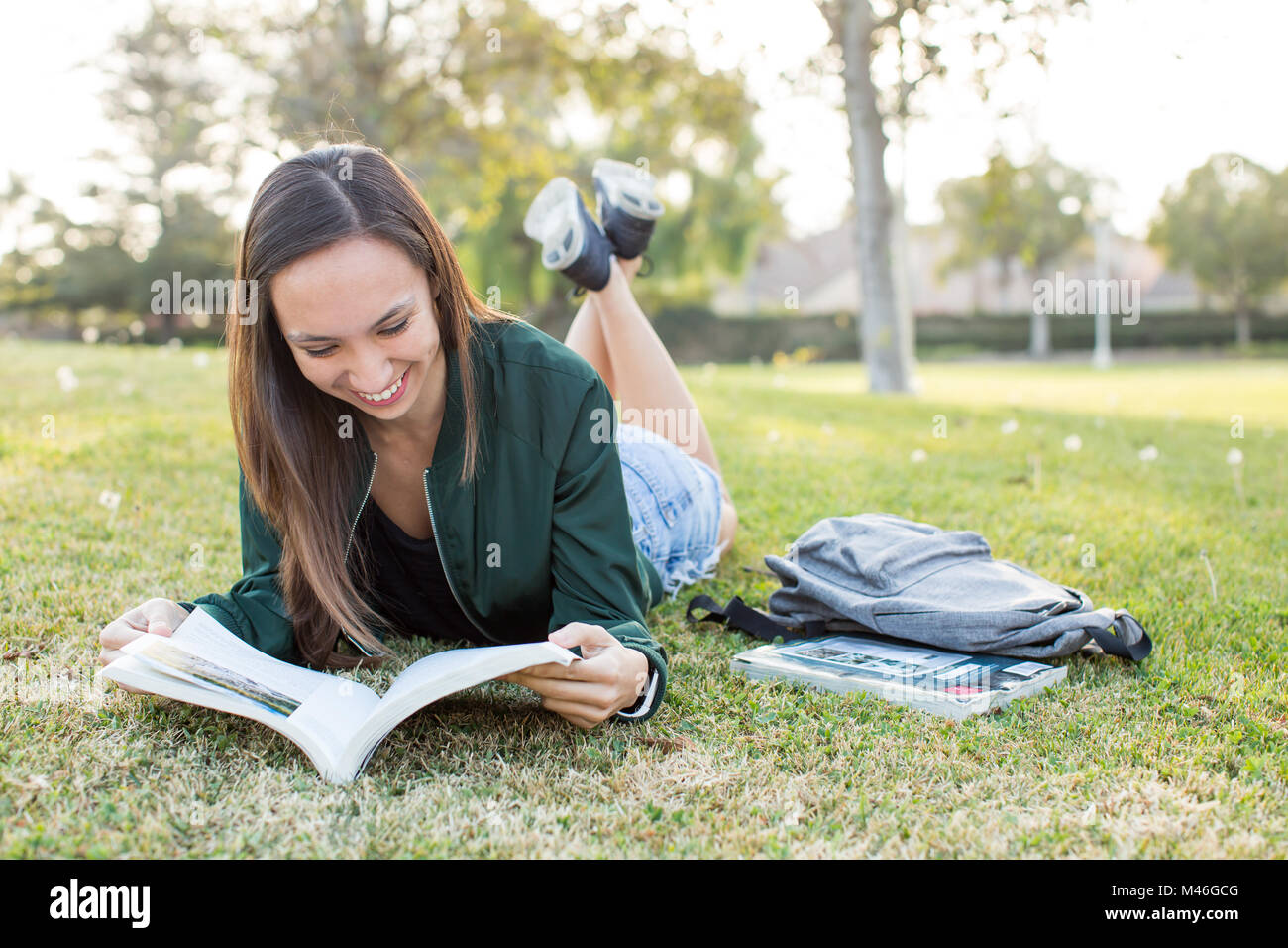 Young ethnic woman outside studying school book Stock Photo