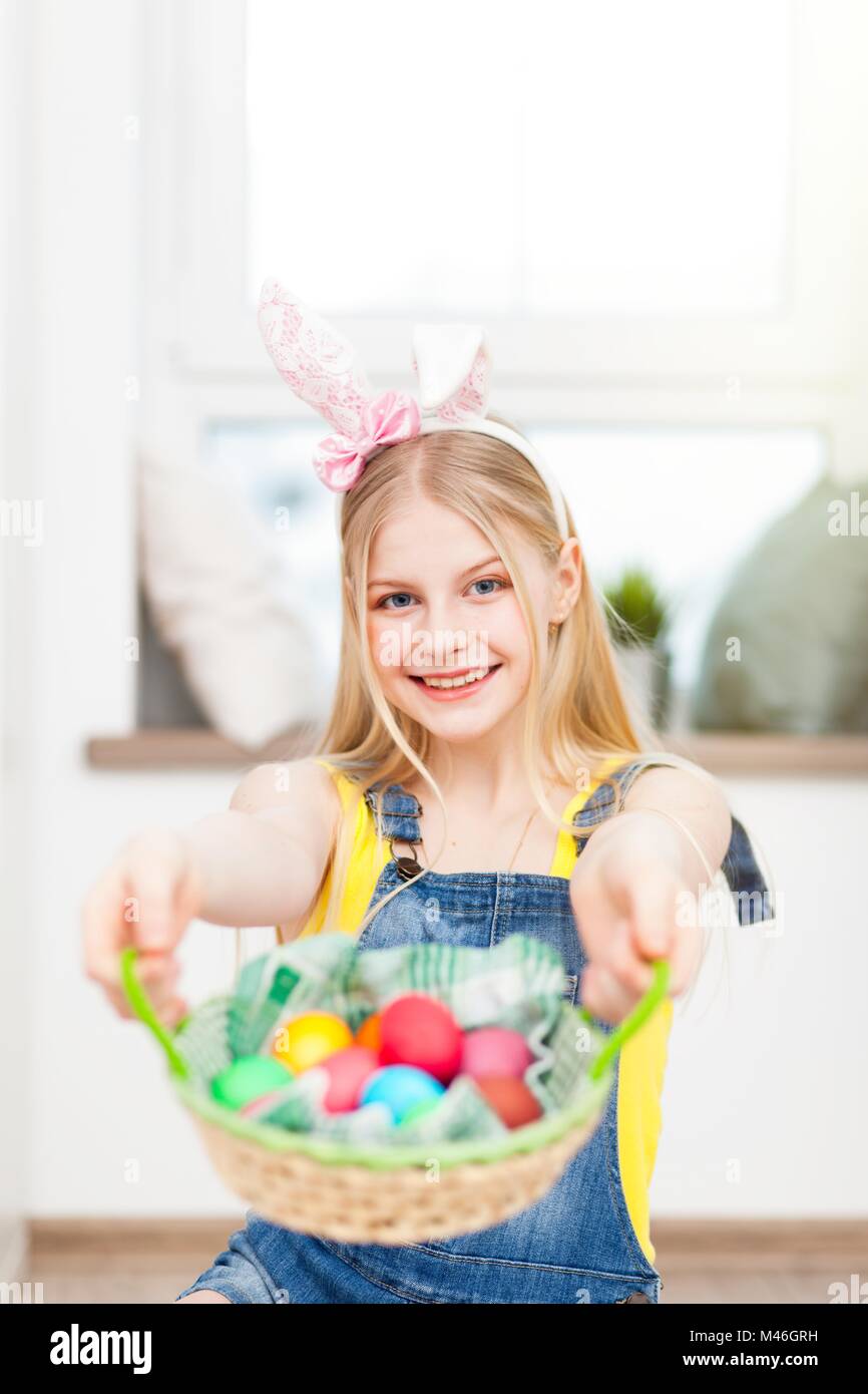 Teenage girl wearing bunny ears holding Easter eggs Stock Photo - Alamy