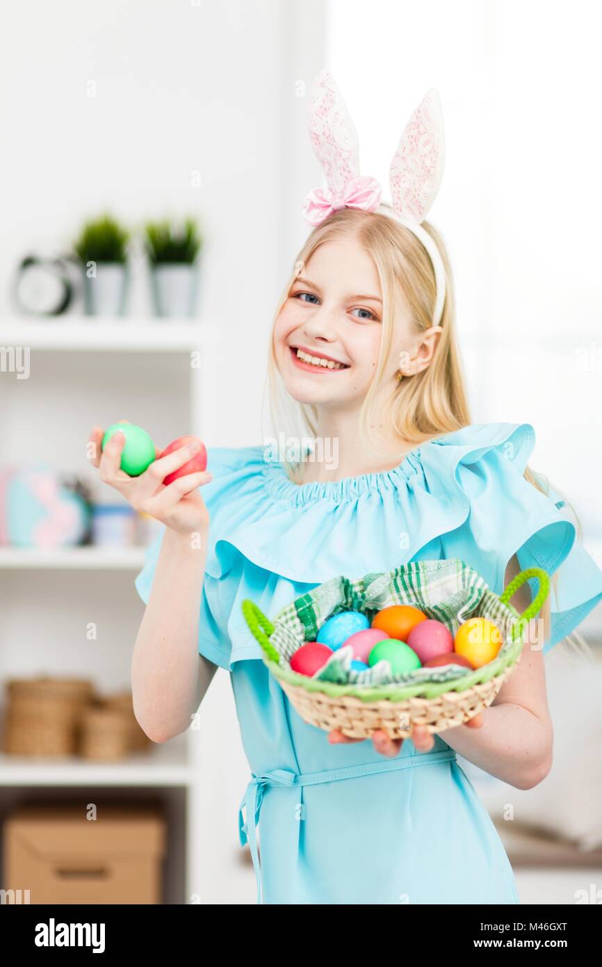 Teenage girl wearing bunny ears holding Easter eggs Stock Photo - Alamy