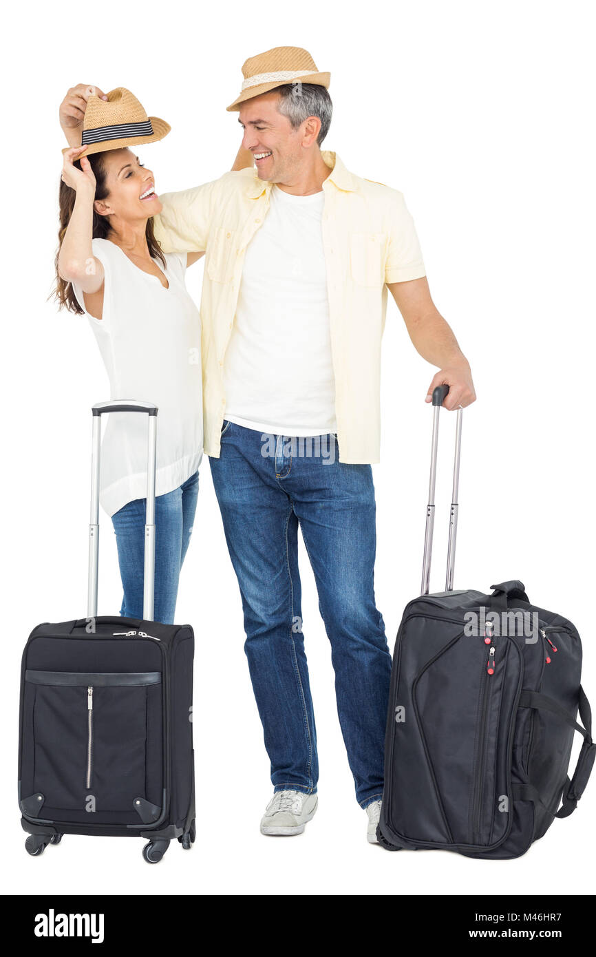 Happy couple embracing with straw hat and suitcase Stock Photo Alamy