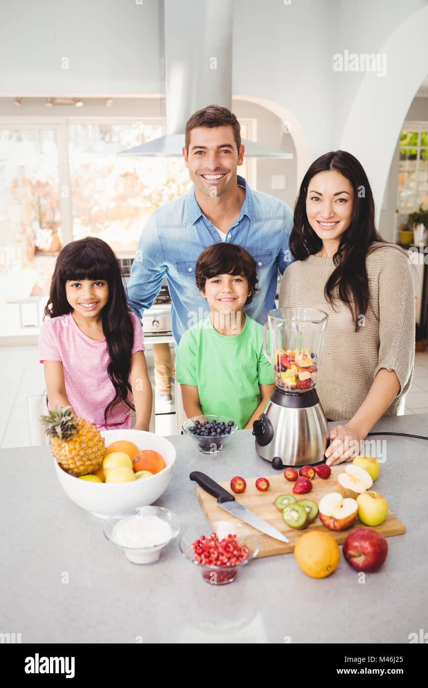 Portrait of smiling family preparing fruit juice Stock Photo
