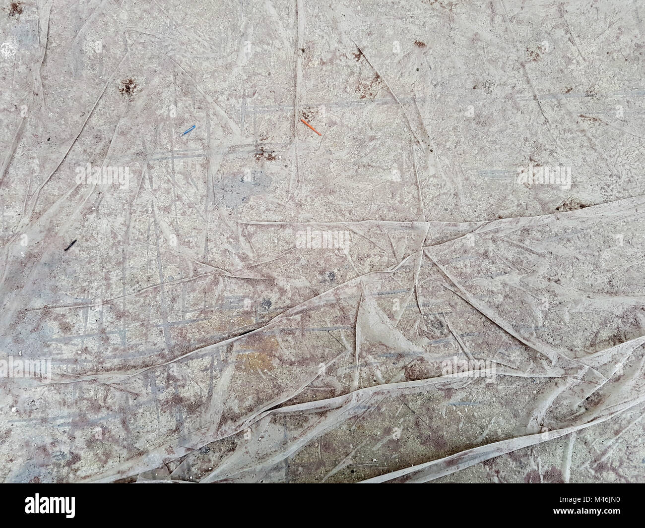 Wet, wrinkled dirty thin paper, collected in folds on a horizontal surface, in the lower right corner of the brown spot. Stock Photo
