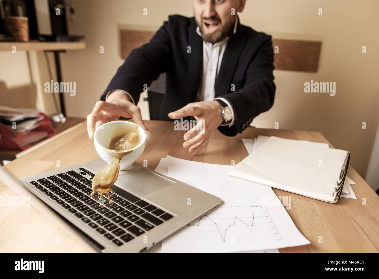 Coffee in white cup spilling on the table in the morning working day at office table Stock Photo