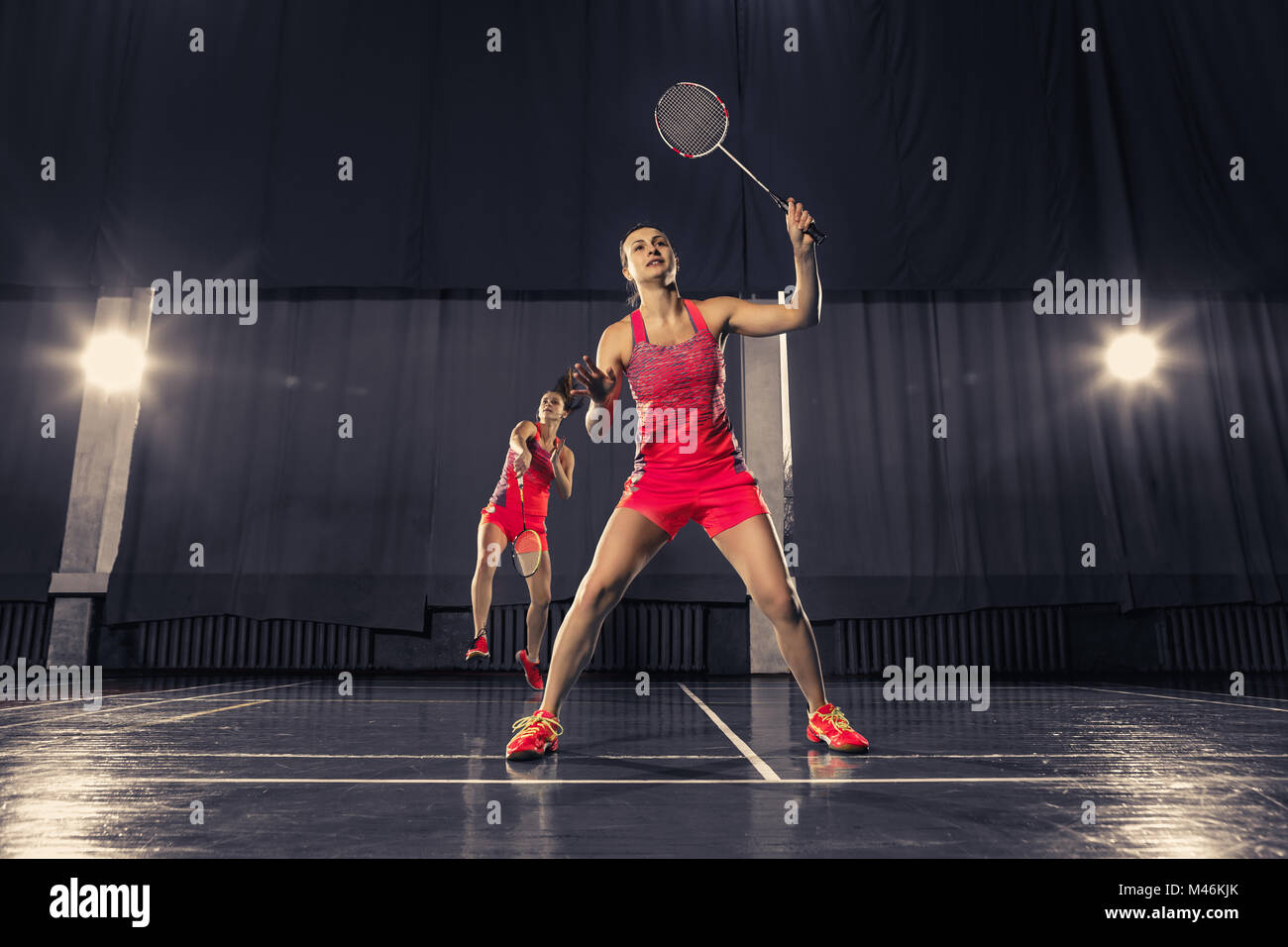 Young women playing badminton at gym Stock Photo