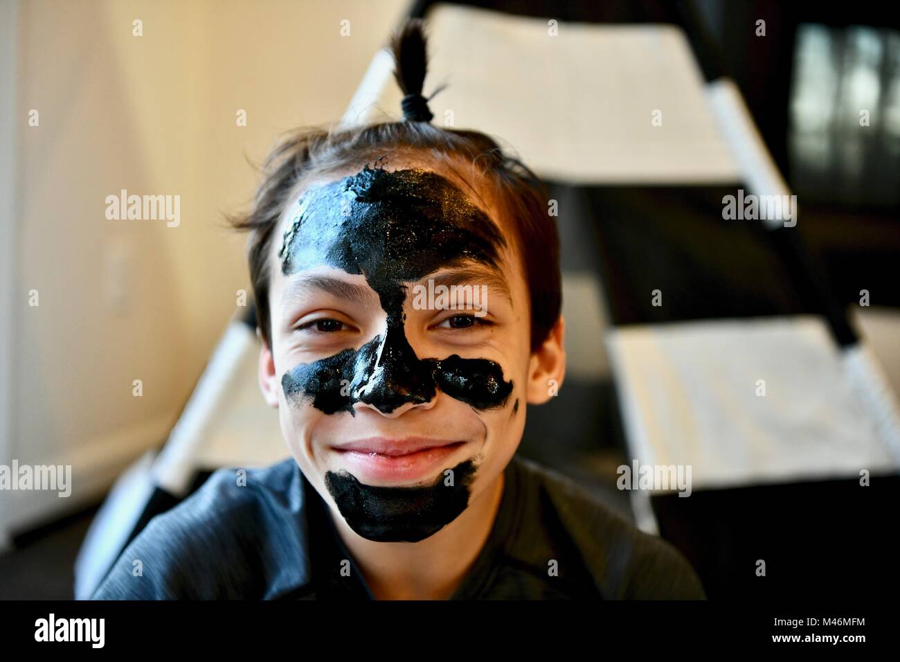 Teen boy wearing black facial cleansing mask Stock Photo