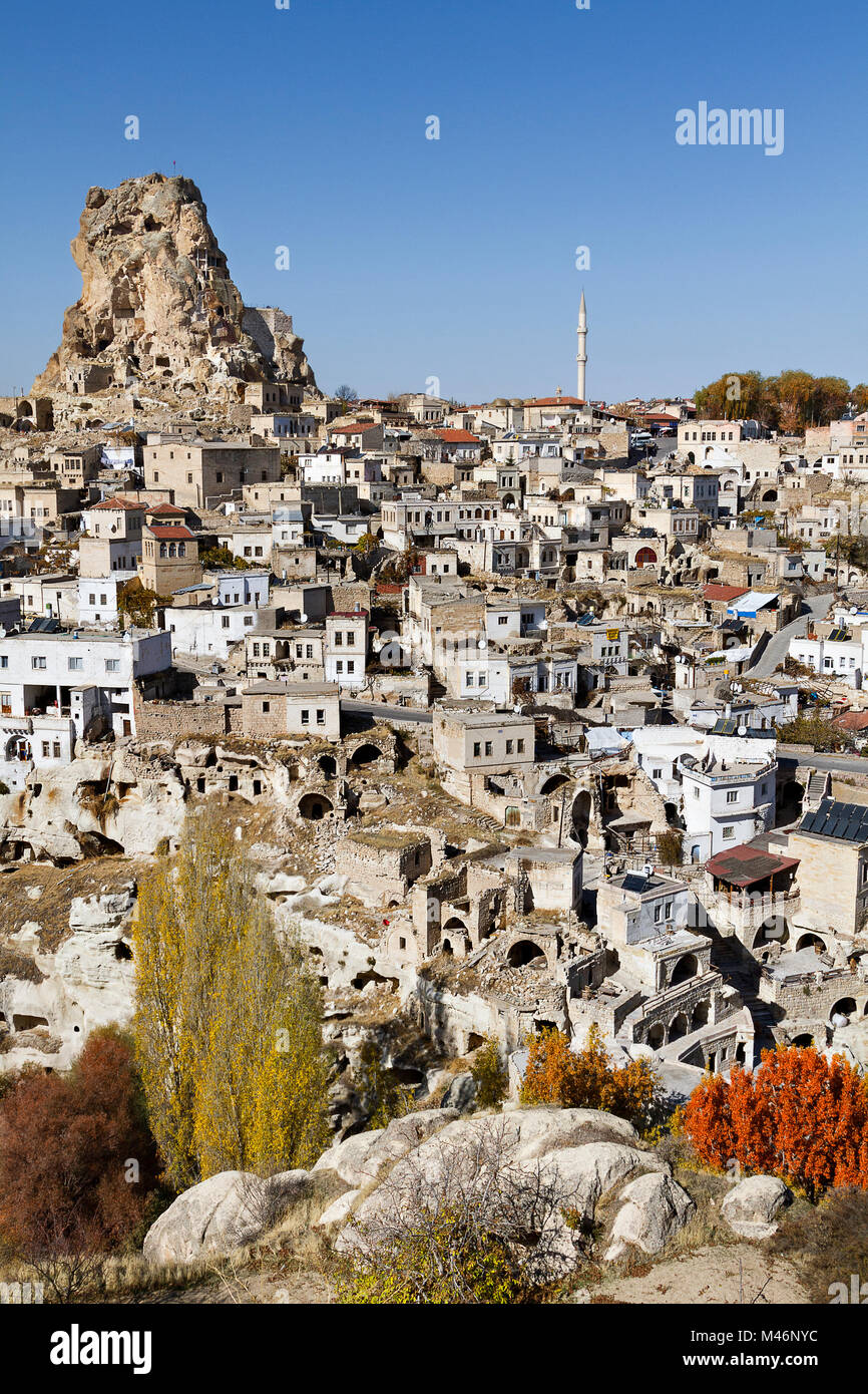 View over the rock formations and cave dweliings with tall rock formation known as Ortahisar Castle, in Cappadocia, Turkey. Stock Photo