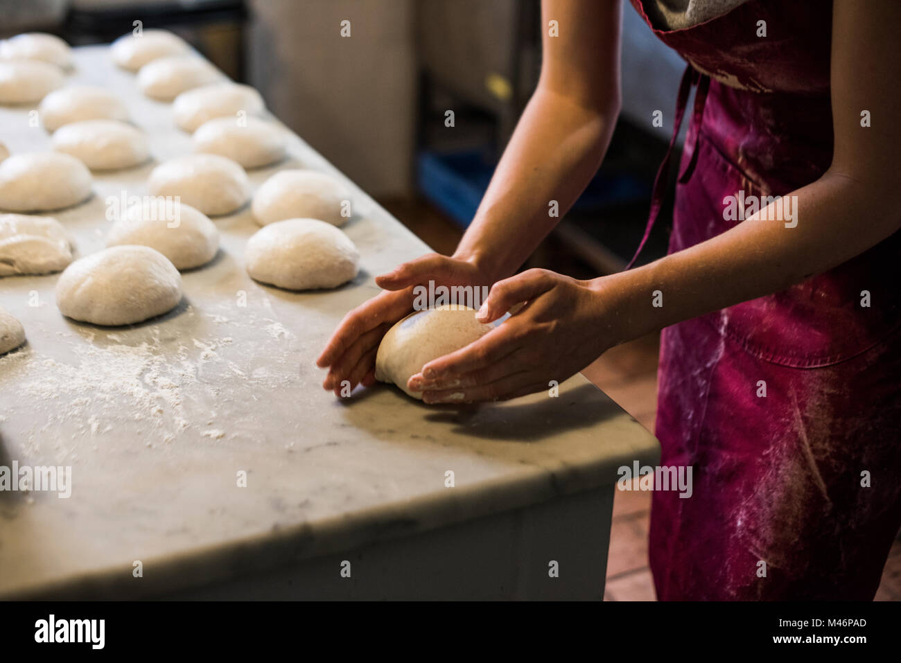 Woman in apron shaping pizza dough Stock Photo