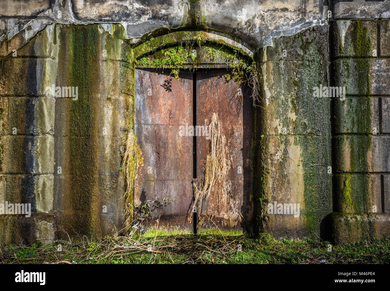 An old, weathered and damp cast iron door entrance to a Victorian lockup in Liverpool Uk. Stock Photo