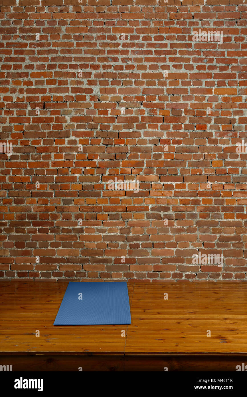 https://c8.alamy.com/comp/M46T1K/gym-mat-on-wooden-podium-with-brick-wall-on-background-M46T1K.jpg