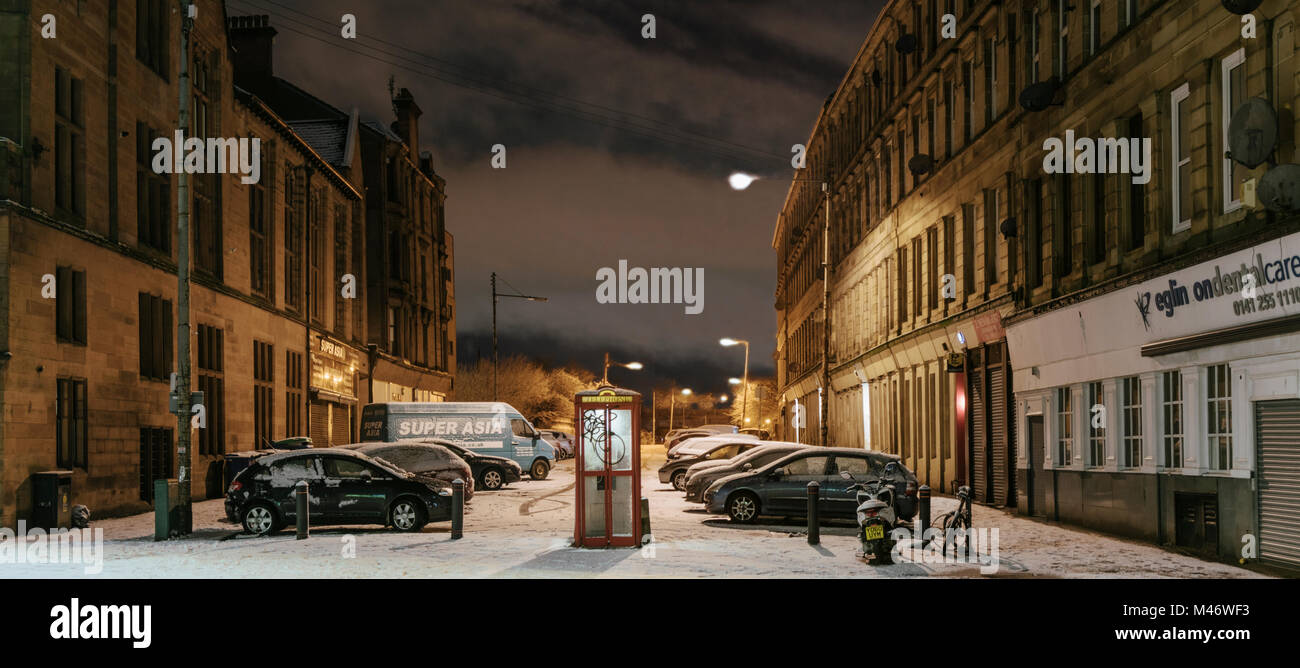 A public phone box in deserted Glasgow city street at night after a fall of snow, Scotland, UK Stock Photo
