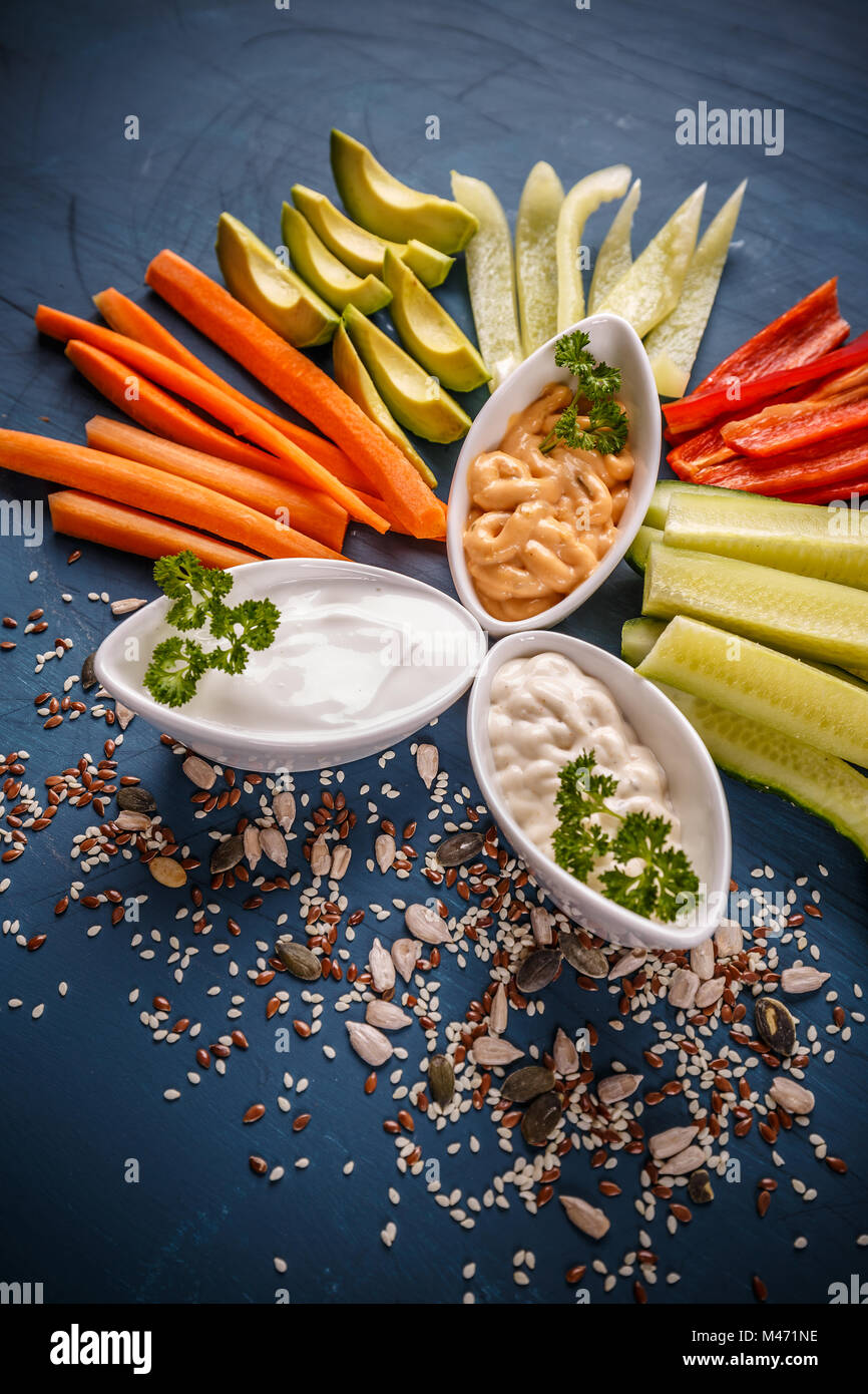 Assorted fresh vegetables with dips on blue background Stock Photo Alamy