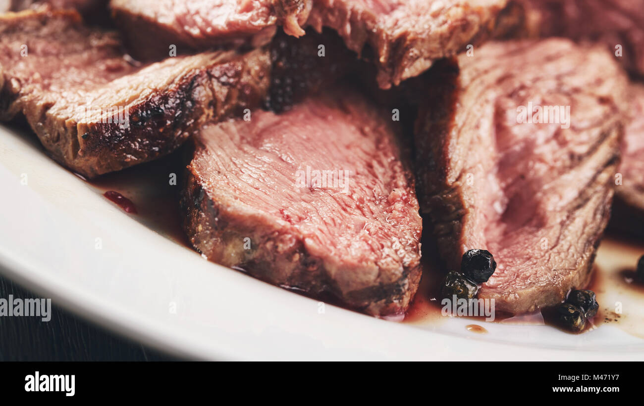 sliced beef steak on white plate close up Stock Photo