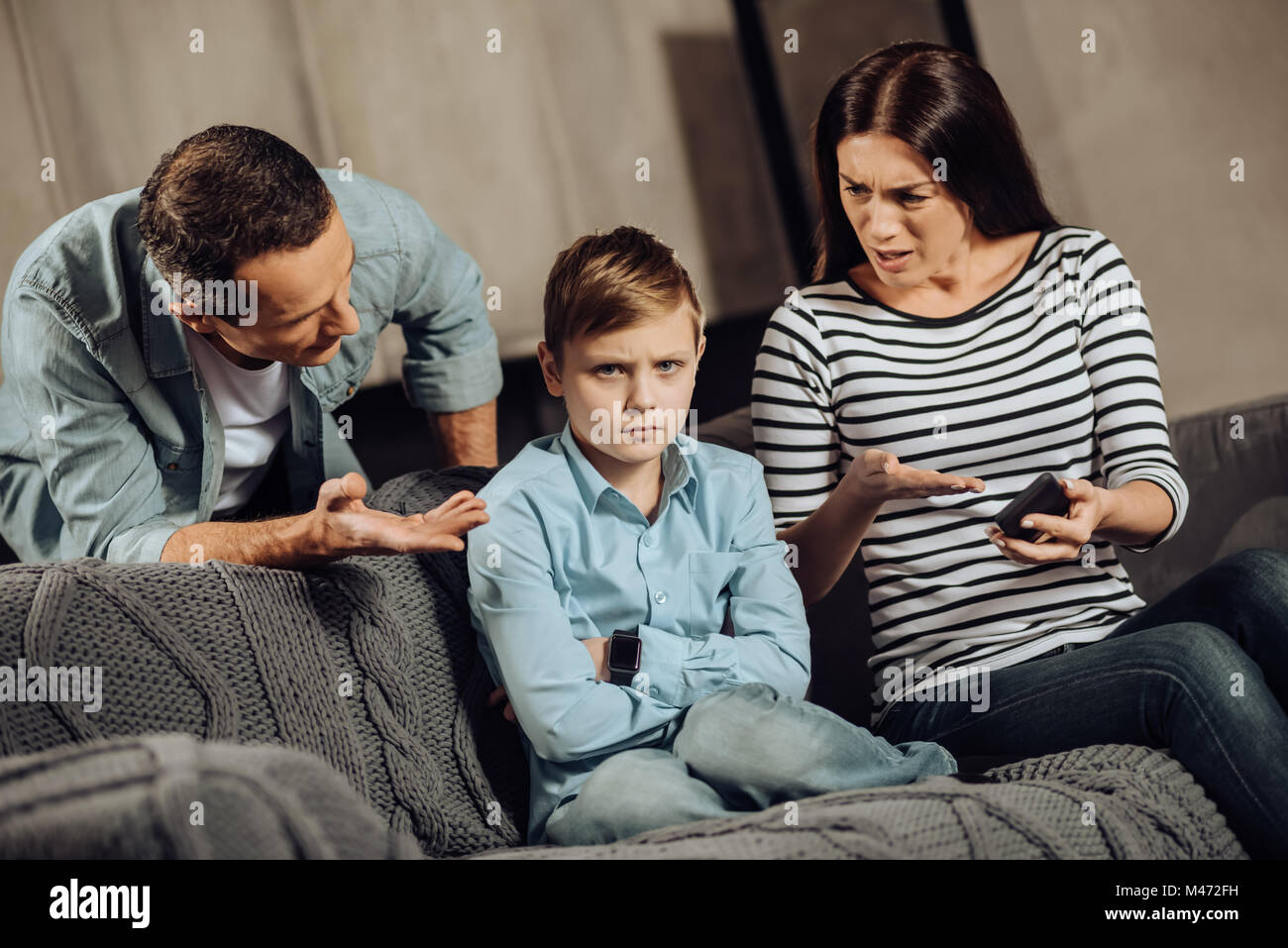 Young parents explaining son about drawbacks of binge-playing Stock Photo
