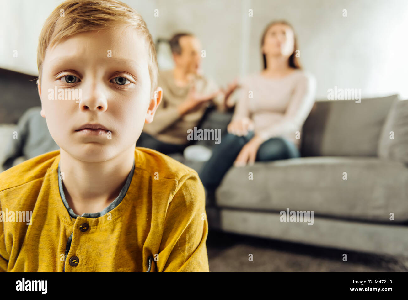 Little boy feeling lonely while his parents quarrelling Stock Photo