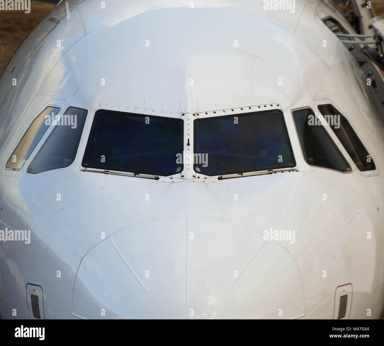 Close up of the front of a passenger jet showing the cockpit windows Stock Photo