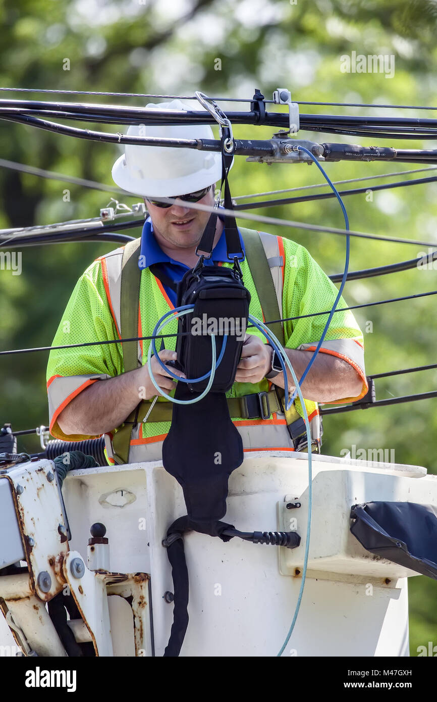 Power line Technician working from a cherry picker. Stock Photo