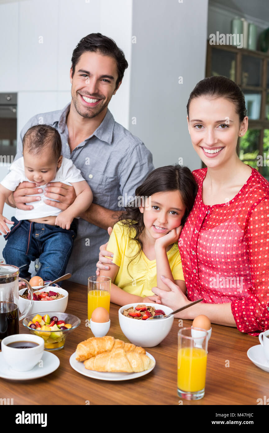 Portrait of smiling family at breakfast table Stock Photo - Alamy