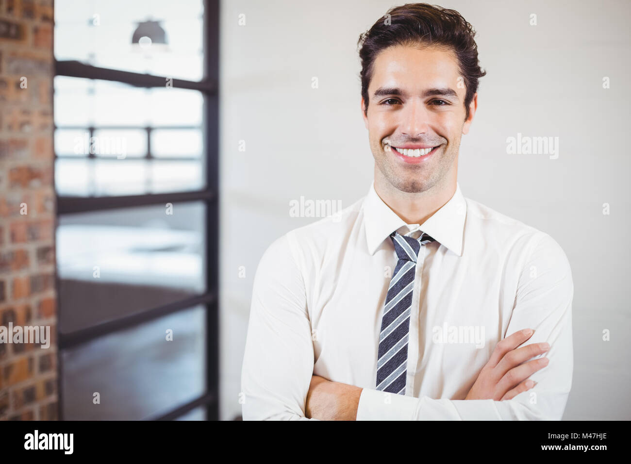 Portrait of smiling businessman with arms crossed Stock Photo - Alamy
