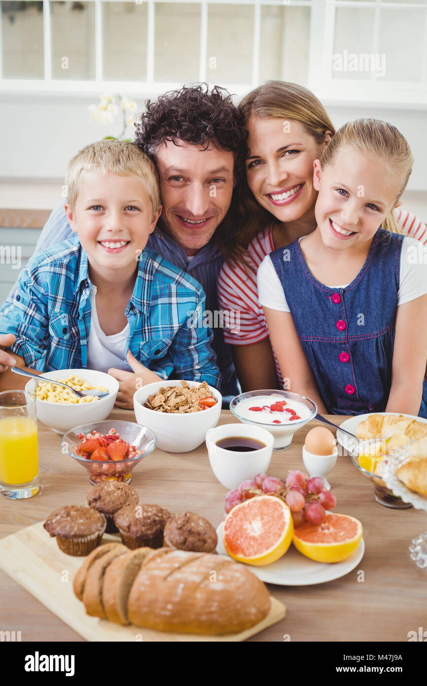 Portrait of family smiling while having breakfast Stock Photo - Alamy