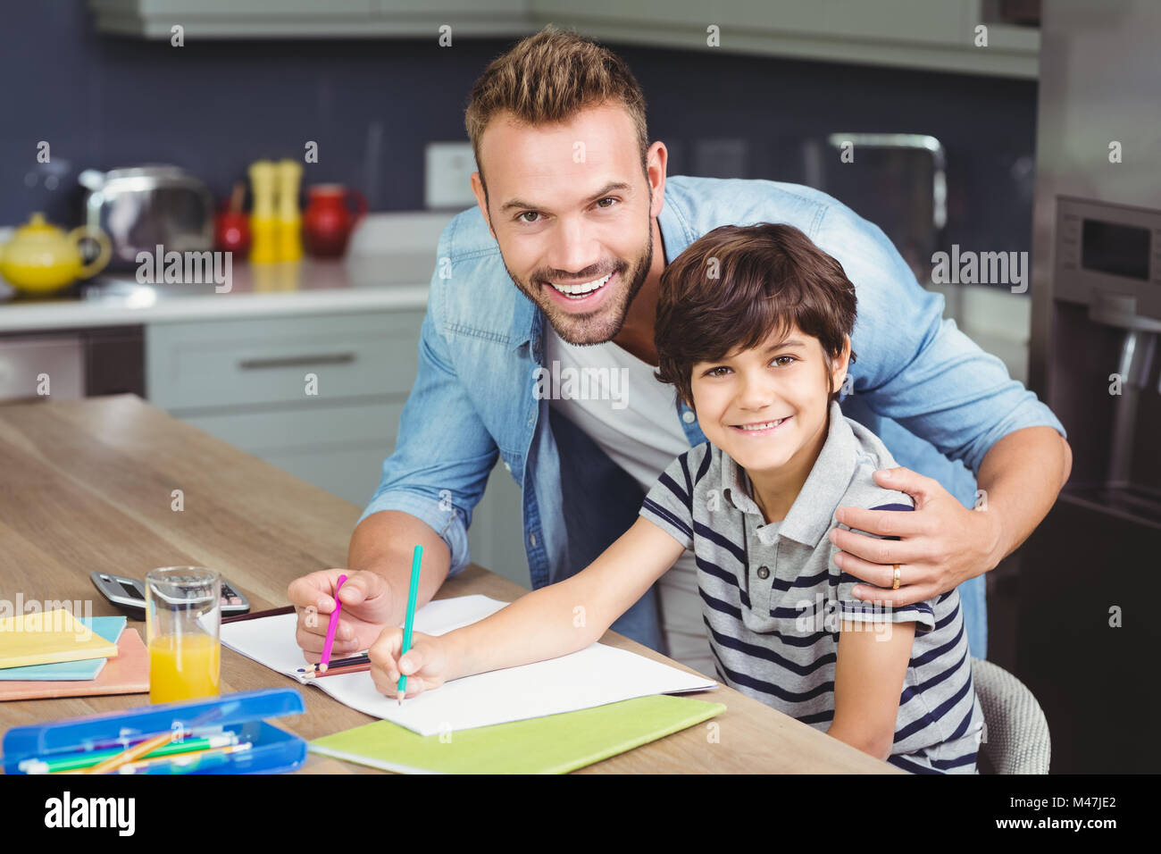 Portrait of father assisting boy in solving maths Stock Photo