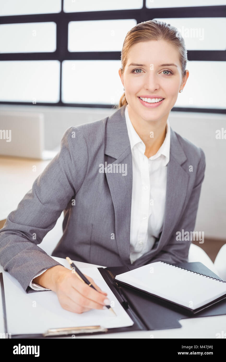 Young businesswoman with documents sitting at desk Stock Photo - Alamy