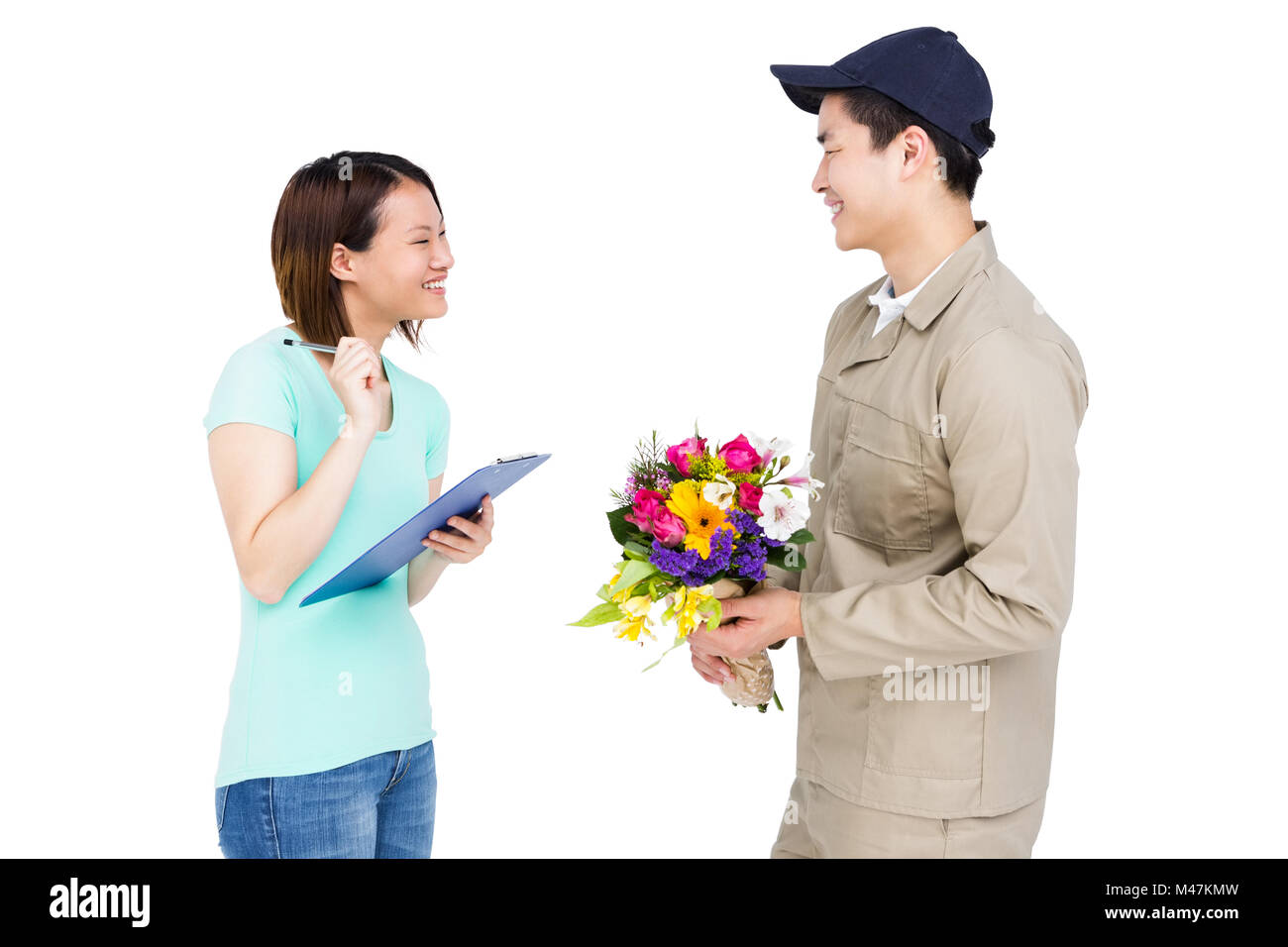 Delivery man taking signature of woman while delivering flowers Stock