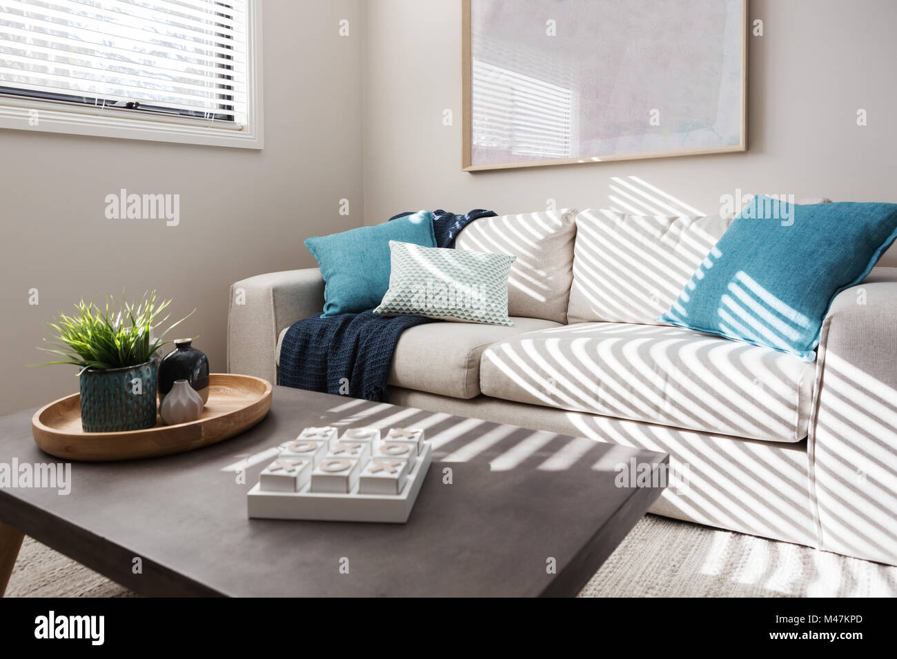 Neutral living room with textured fabrics and teal accents Stock Photo