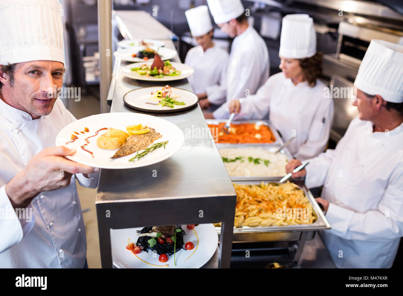 Chef handing dinner plates through order station Stock Photo - Alamy