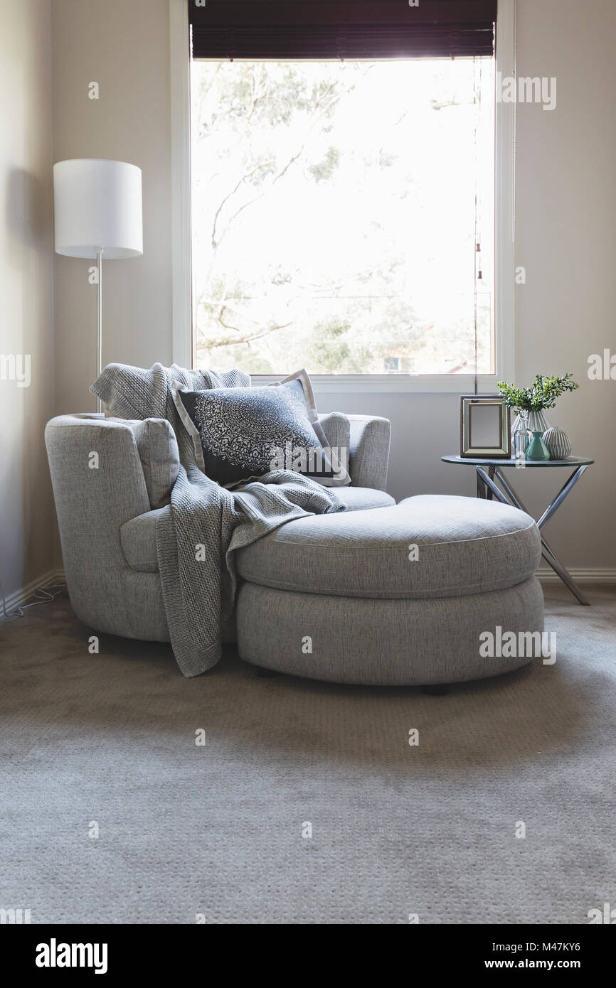 luxury grey bedroom corner armchair under a window stock