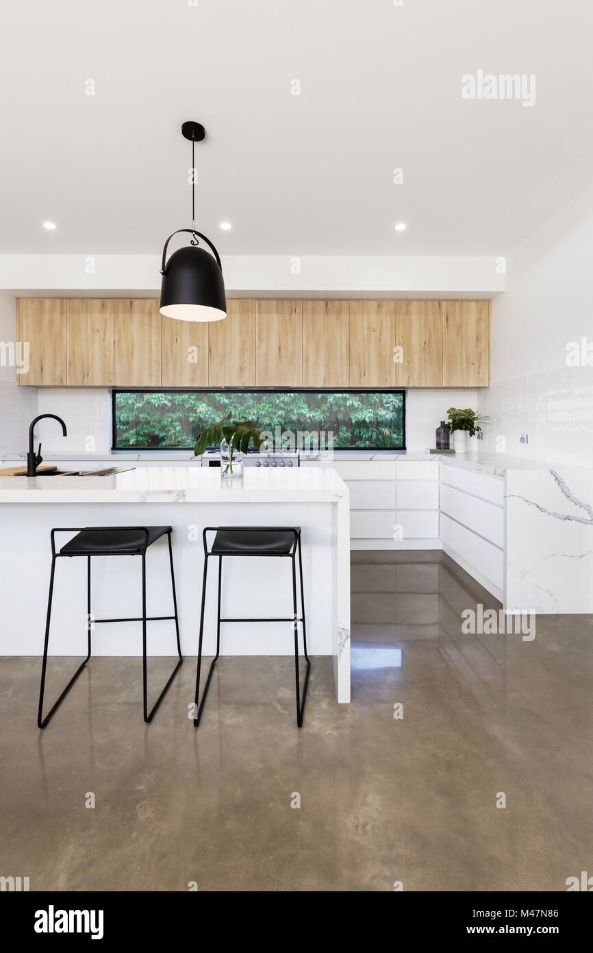 Luxury kitchen with carrera marble waterfall island bench Stock Photo