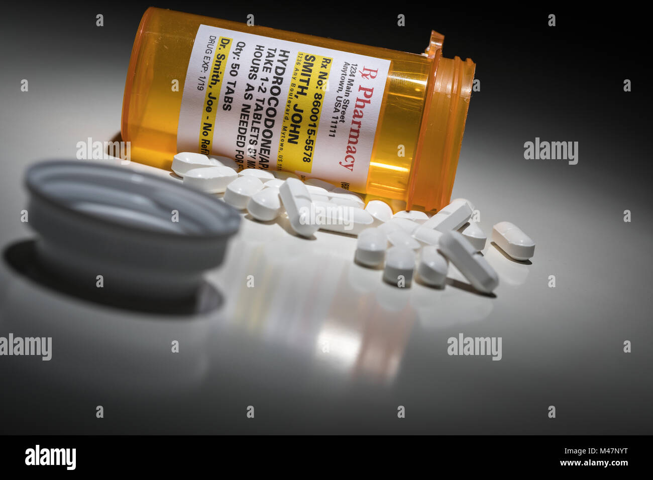 Hydrocodone Pills and Prescription Bottle with Non Proprietary Label. No model release required - contains ficticious information. Stock Photo