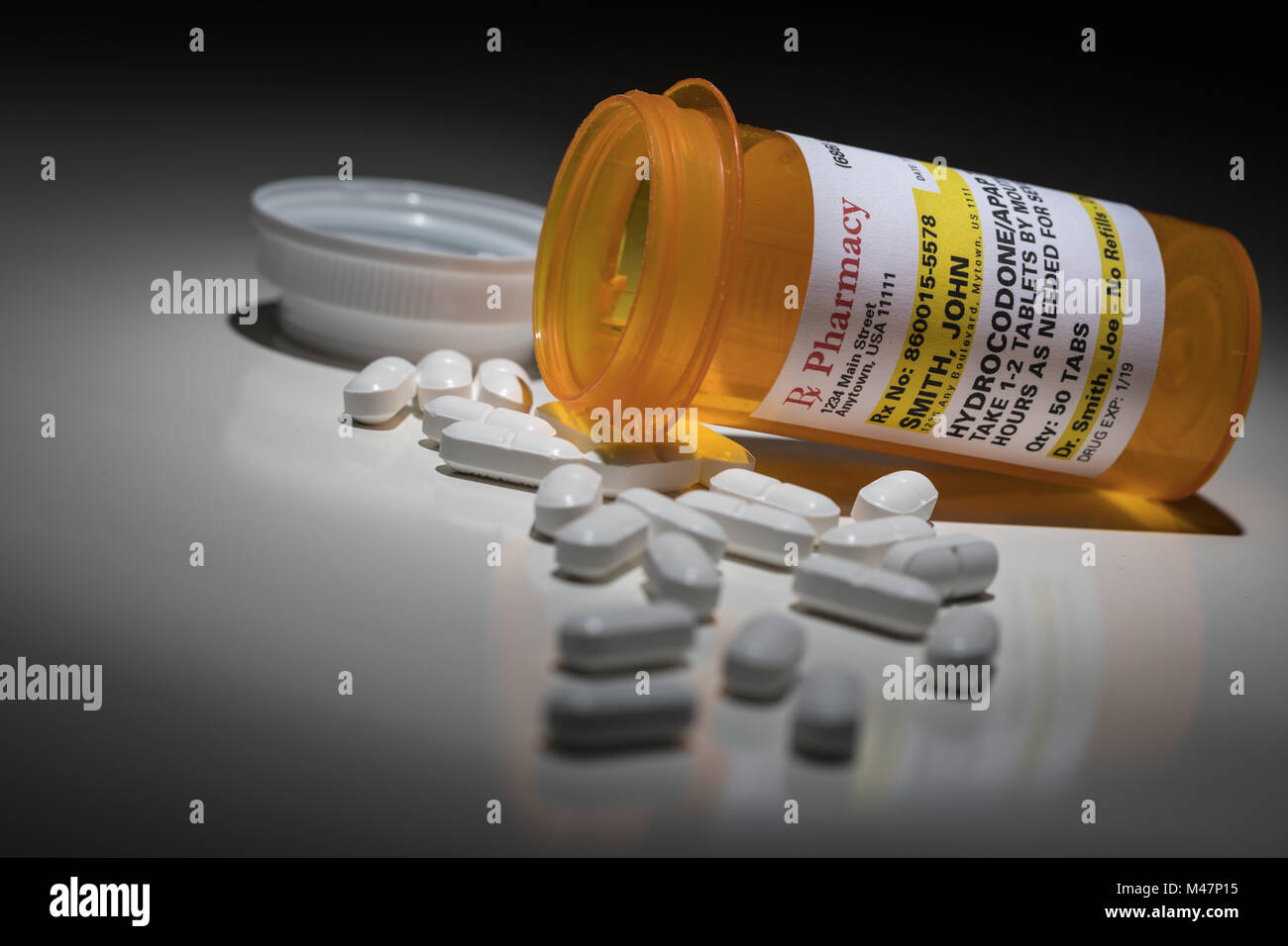 Hydrocodone Pills and Prescription Bottle with Non Proprietary Label. No model release required - contains ficticious information. Stock Photo