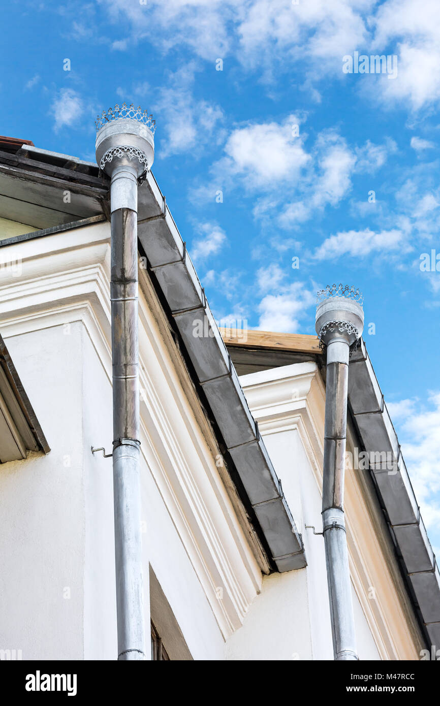 drainpipes for rain drainage on a house roof Stock Photo