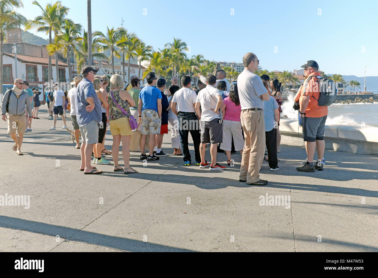 Tour group stands along the seawall on the malecon in Puerto Vallarta, Mexico. Stock Photo
