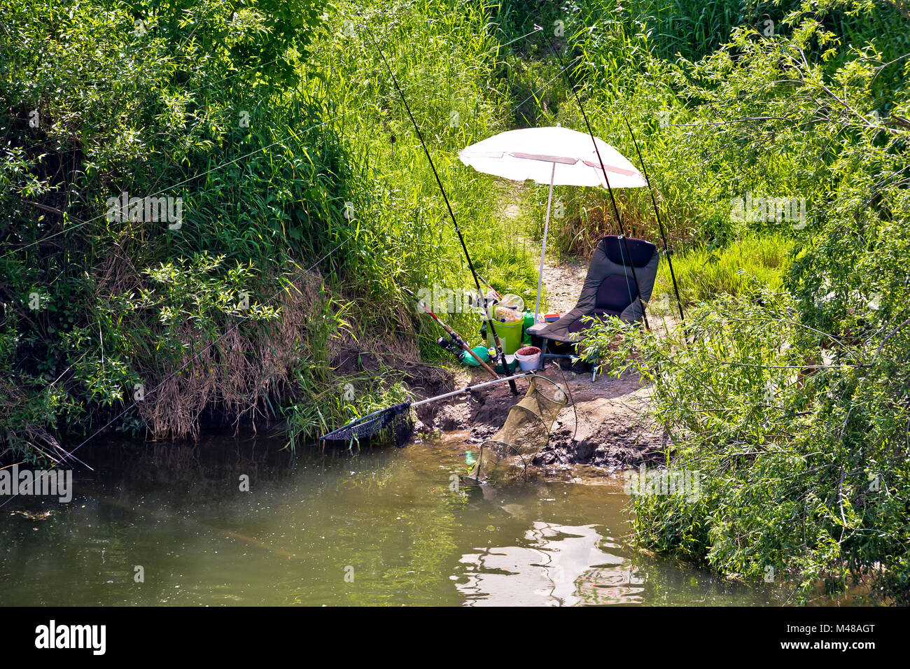 Fishing spot and gear in green landscape Stock Photo