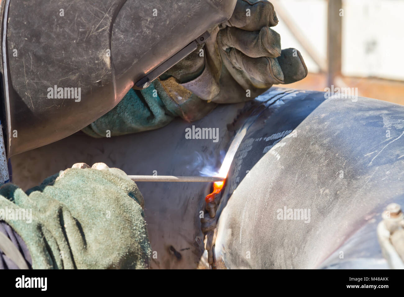 welder performs welding works on pipelines stainless steel Stock Photo