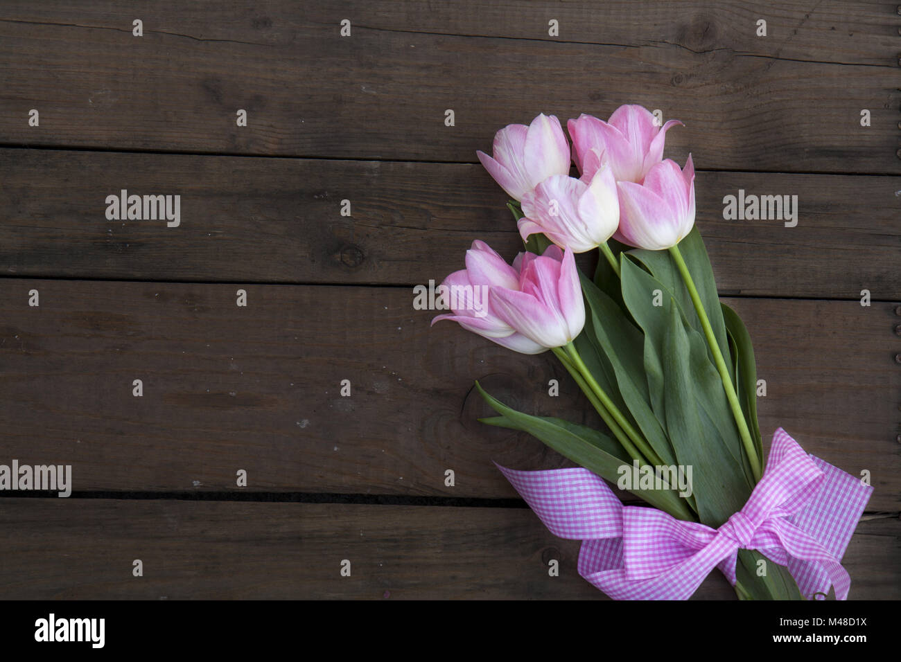 Beautiful bouquet of pink tulips on dark wooden background Stock Photo ...