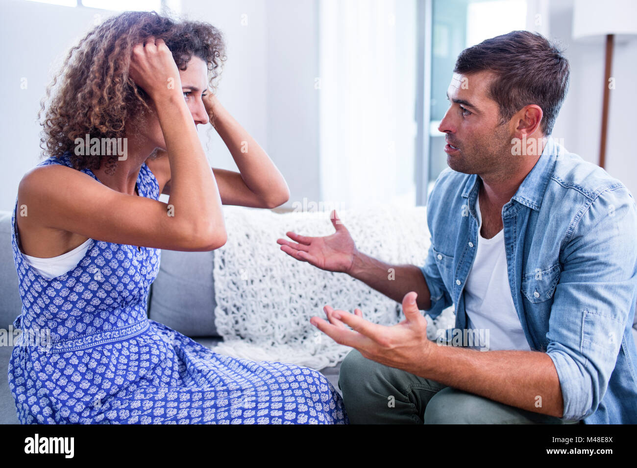 Young couple sitting together and discussing after a fight Stock Photo ...